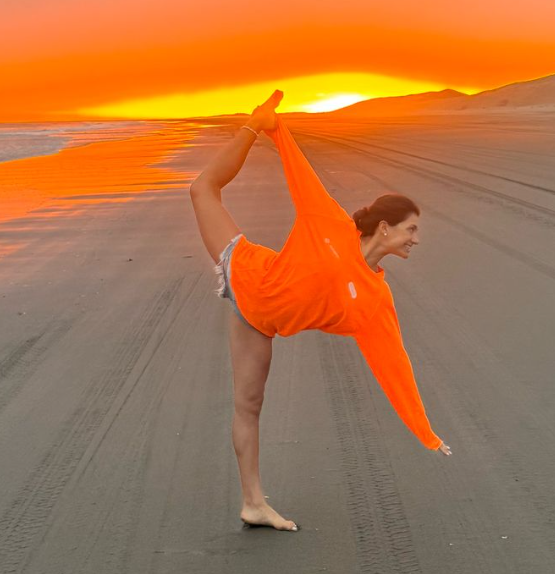 Maria Guillermina Hendriksen pratica una posizione Yoga (Natarajasana) sulla spiaggia al tramonto